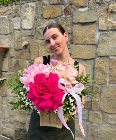 Sweet Thing Tote flower arrangement featuring pink roses, hot pink rose, soft blush blooms, baby’s breath, seasonal greenery and signature ribbon in a hessian gift bag