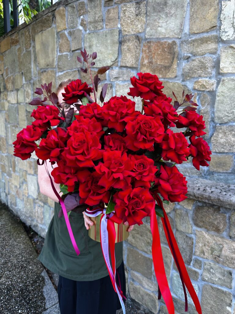 Luxury red rose arrangement featuring premium long-stem red roses with cascading ribbons by The Lush Lily Brisbane florist.