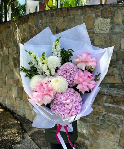 Pink Daydream pastel bouquet with pink roses, hydrangea and seasonal flowers wrapped in white paper