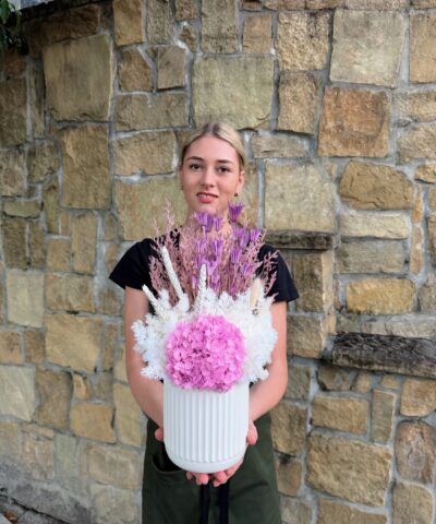Lilac Whisper dried and preserved flower arrangement featuring pink hydrangea, lilac preserved flowers and white foliage in a white ceramic vase.