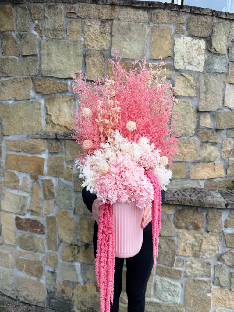 Pink Fizz dried and preserved flower arrangement with pink hydrangea, white textured flowers and cascading pink amaranthus in a ribbed pink vase.