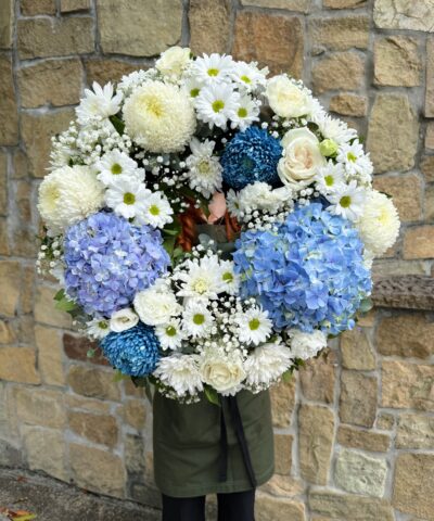 Blue Serenity Wreath featuring blue hydrangeas, white roses, chrysanthemums and daisies – funeral flowers Brisbane by The Lush Lily
