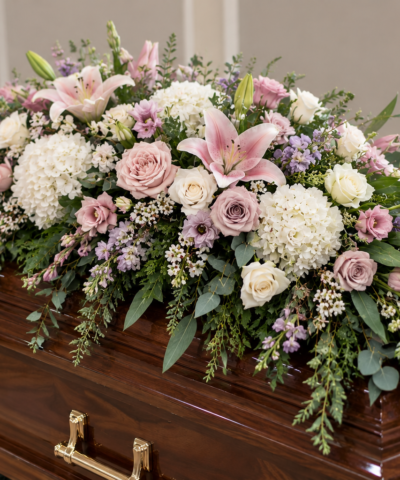 Blushing Serenity Casket Spray with soft pink lilies, blush roses, white hydrangeas and lavender funeral flowers