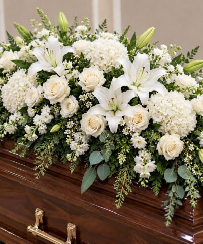 Eternal Peace Casket Spray featuring white lilies, ivory roses, white hydrangeas and cascading eucalyptus greenery