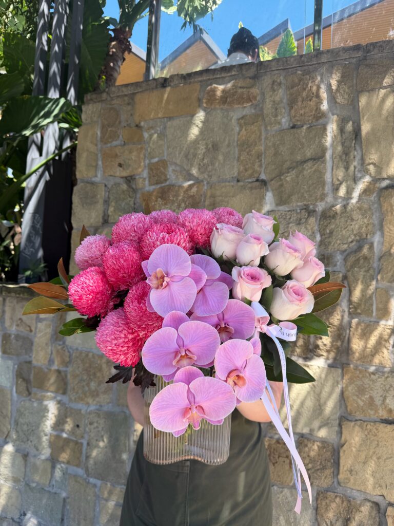 Orchid Crush pink orchid flower arrangement with roses and disbuds in glass vase